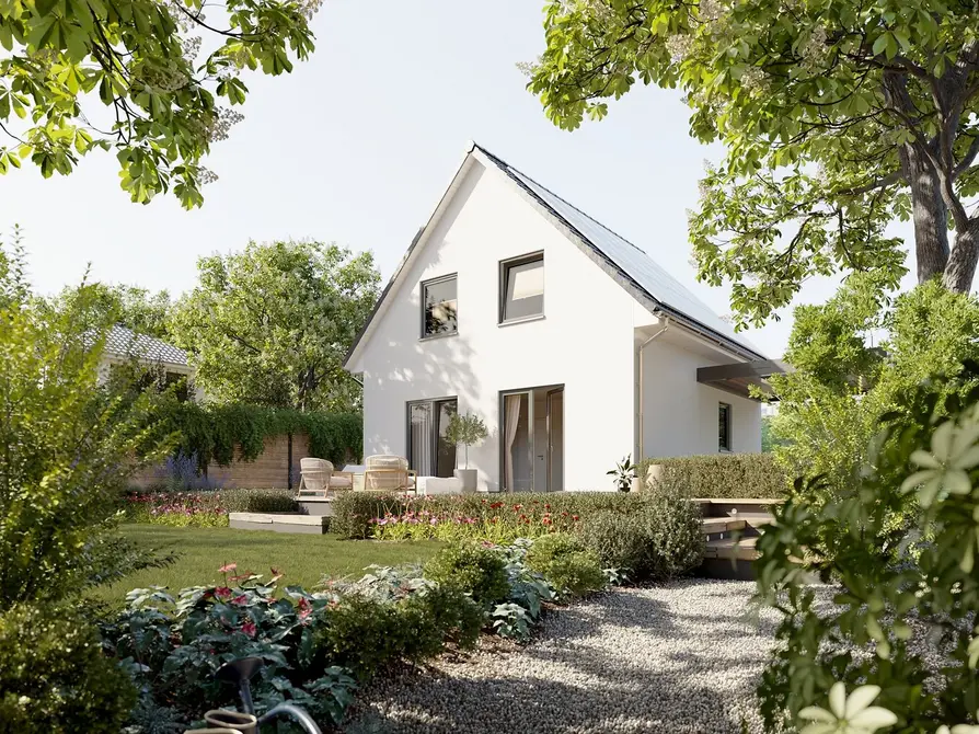 Blick vom Garten auf das Raumwunder 90 mit Terrasse, Gartenmöbeln und bepflanztem Weg bei Tageslicht